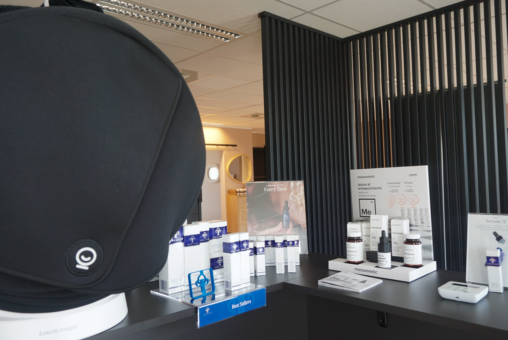 Huidanalysetoestel aan de balie van MED-CLINIC Antwerpen, met daarnaast displays met verzorgings- en serumproducten.